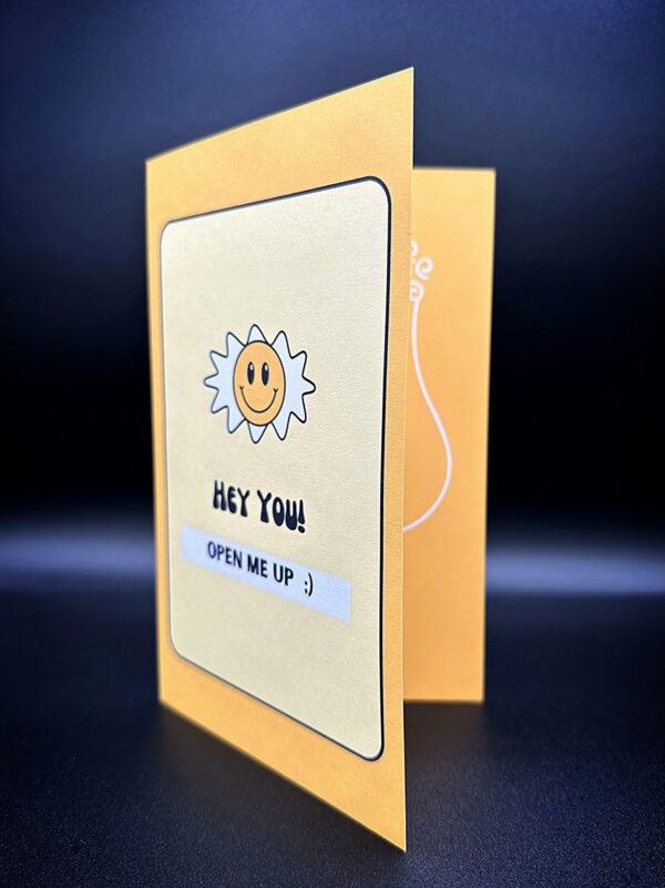 Yellow card with smiley sun and text.