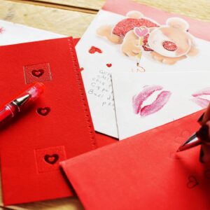 Red envelopes with hearts and a pen.